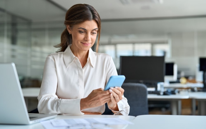 Female office worker looking at mobile phone