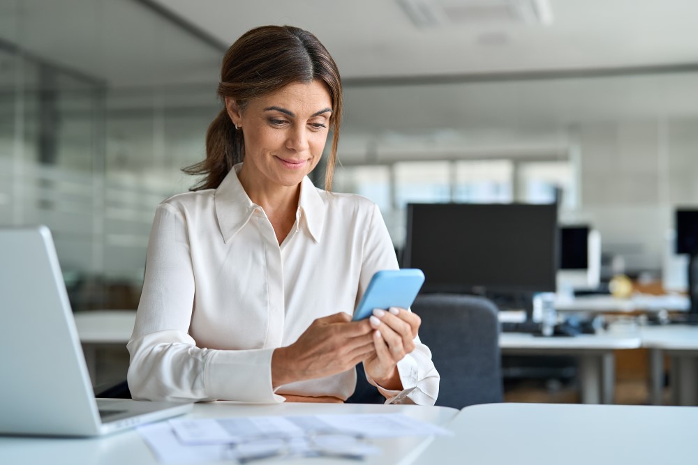 Female office worker looking at mobile phone